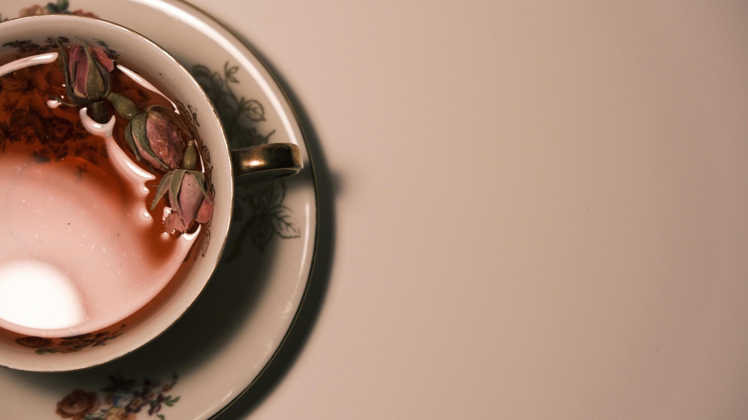 Elegant rose tea in a floral vintage cup with rosebuds, providing a serene tea time moment.